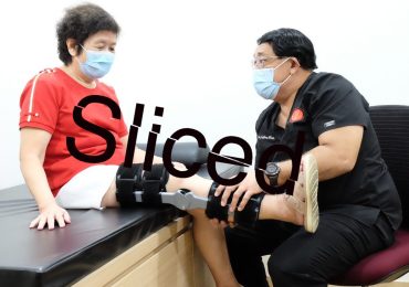 中心整形外科博士董事长兼首席执行官杰弗瑞咀嚼帮助他的一个病人穿新加坡X-Brace南大。